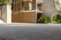 a man is riding a skateboard down the sidewalk in front of an apartment building