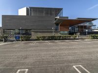 a parking lot with multiple parking spots outside a museum or art gallery, with a parking sign in front