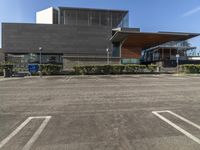 a parking lot with multiple parking spots outside a museum or art gallery, with a parking sign in front