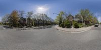 an image of a wide angle shot of the street and homes in a small city