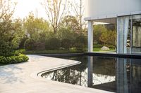 a view of the pool area outside of the house where we are staying is reflected in the water