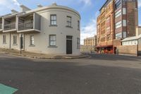 a corner with many windows on it between buildings on a street and a street corner