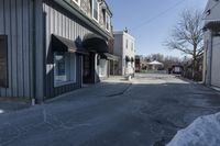 an empty street that is blocked off by snow on the ground in front of a store