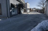 an empty street that is blocked off by snow on the ground in front of a store