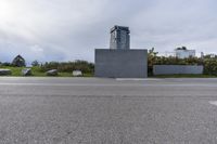 an empty parking lot near a tall building with a sign at the front in a city