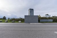 an empty parking lot near a tall building with a sign at the front in a city