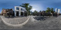 a 360 - vision photo of a residential area with cars on the street and several buildings