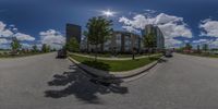 a panoramic image of a big building on the corner of the street and a tree in front of it