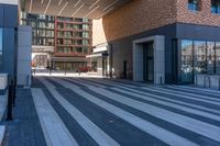 a view down the walkway in front of the building with bicycles parked next to it