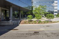 a car drives down the street next to buildings and trees outside of the building,