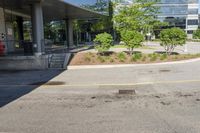 a car drives down the street next to buildings and trees outside of the building,