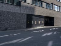 the building is surrounded by concrete and brick walling that says pierre on a black sign