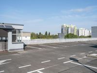 a parking lot with white markings in front of the buildings and some buildings in the background