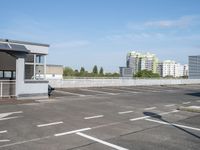 a parking lot with white markings in front of the buildings and some buildings in the background