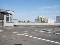 a parking lot with white markings in front of the buildings and some buildings in the background