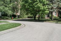 a suburban neighborhood with trees, houses and lawns around the corner of the street