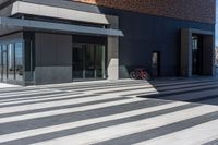 an empty brick building with a large glass door and a bicycle in the corner of it