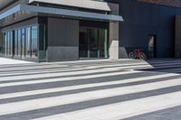 an empty brick building with a large glass door and a bicycle in the corner of it