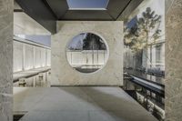 a stone wall in front of a circular window and benches on top of it are surrounded by cement wall tiles