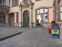 an open door on the street and boxes outside the front of the building in front of the buildings