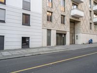 an apartment building on a side walk near the street by itself with no parking sign on it