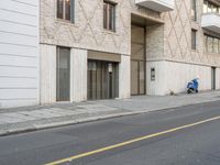 an apartment building on a side walk near the street by itself with no parking sign on it