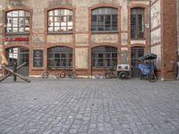 an image of an old building with a brick floor and bicycles on the sidewalk in front