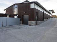 an outdoor building that has multiple garage spaces in the front and a driveway below it