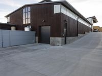 an outdoor building that has multiple garage spaces in the front and a driveway below it