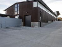 an outdoor building that has multiple garage spaces in the front and a driveway below it