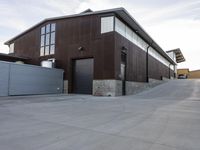 an outdoor building that has multiple garage spaces in the front and a driveway below it