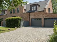 a brick and stone house with a large driveway and front entry in germany, europe or france