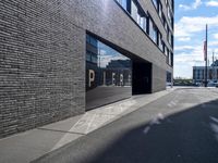 the entrance of pier 64 is clear and empty during the day in this photograph, taken from the side of the street