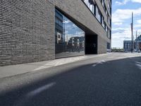 the entrance of pier 64 is clear and empty during the day in this photograph, taken from the side of the street