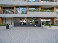 the building has a large courtyard with glass doors and trees on the wall around it