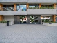 the building has a large courtyard with glass doors and trees on the wall around it