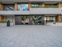 the building has a large courtyard with glass doors and trees on the wall around it