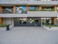 the building has a large courtyard with glass doors and trees on the wall around it