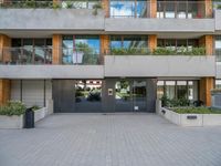 the building has a large courtyard with glass doors and trees on the wall around it