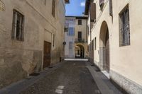 an alley in the village with doors on each side of it and a building behind it