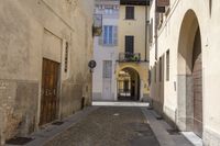 an alley in the village with doors on each side of it and a building behind it