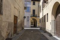 an alley in the village with doors on each side of it and a building behind it