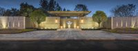 a building with a lit front and walkway at night in california's redwood hills