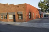 a red building with white trim and windows is on the side of a street with black shutters