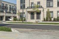 a man is riding his bike down a street near an apartment building in toronto, canada