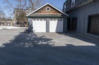 the front door of the garage is open with no doors and a driveway area is visible