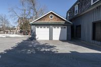 the front door of the garage is open with no doors and a driveway area is visible