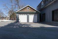 the front door of the garage is open with no doors and a driveway area is visible