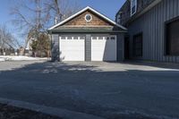 the front door of the garage is open with no doors and a driveway area is visible