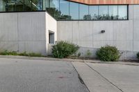 a fire hydrant sits at the corner of a sidewalk with a building in the background